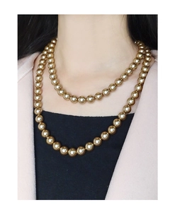 Close-up of double-layer champagne gold pearl necklace on model with elegant drape