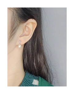 Macro view of sterling silver star-shaped stud earring with a white natural pearl detail