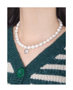 Détail du pendentif étoile de mer en argent et pierres roses sur collier de perles