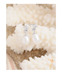 Close-up of S925 silver star stud earrings with natural pearls on a beach coral background