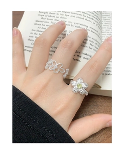 Detailansicht von S925 Silber Blumenringen mit grünem Zirkon auf offenem Buch