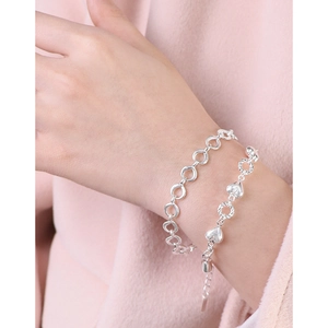 S925 sterling silver heart charm link bracelet set worn on wrist with elegant lighting