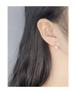 Close-up of S925 silver star earring with natural pearl drop worn on ear