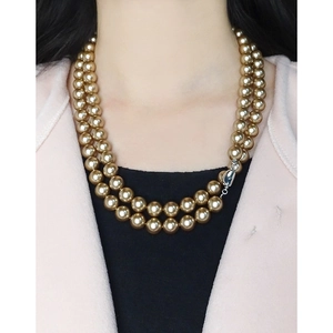 Double-layer champagne gold pearl necklace with silver heart clasp on female model