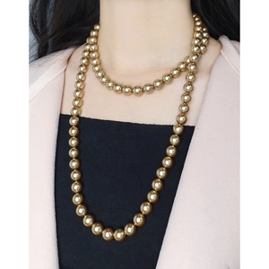 Elegant double-layered champagne gold pearl long necklace on a professional model outfit