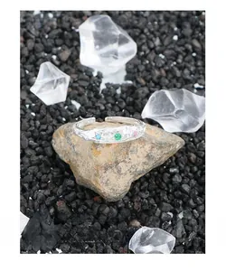 Makroaufnahme des S925 Sterlingsilberrings mit Faltenstruktur und drei bunten Steinen