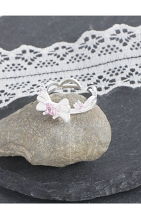 Vue macro d'une bague nœud en argent S925 avec zircon rose sur pierre et dentelle