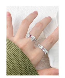 Détail de bagues en argent S925 avec nœud rose, zircon et motifs de cœur évidé