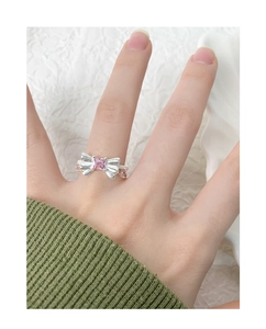 Gros plan d'une bague nœud en argent S925 avec zircon rose sur la main d'un mannequin