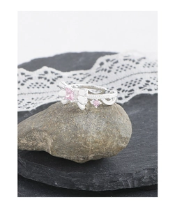 Détail d'une bague nœud en argent S925 avec zircons roses sur support rocheux