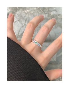 Detail eines S925 Silberrings mit Faltenstruktur und drei bunten Zirkoniasteinen an der Hand