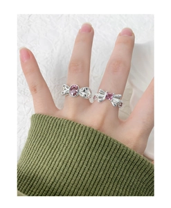 Vue détaillée de bagues nœud en argent S925 avec zircons roses portées sur la main