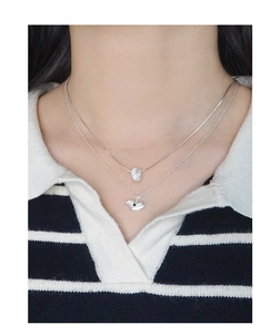 Gros plan d'un collier double couche en argent S925 avec pendentif cœur et gemme noire