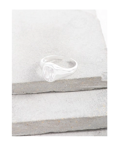 Macro shot of silver sugar cube zircon ring on textured stone showcasing fine craftsmanship