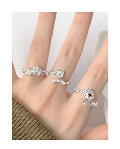 Detail of silver rose rings with red zircon stone and textured floral vine design