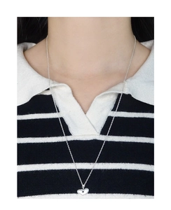 Détail du collier coeur en argent S925 avec étoile sur un haut à rayures noir