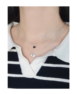 Détail d'un collier double épaisseur avec cœurs noir et argenté porté sur mannequin