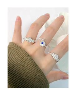 Detail showing stacked S925 silver rose rings with blue zircon inlay on hand