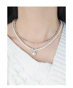 Detail of elegant S925 silver double-layered necklace with bow knot and pearls