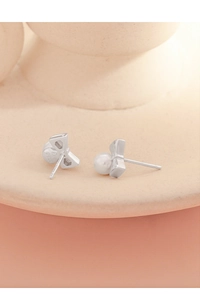 Détail macro du poinçon S925 sur des boucles d'oreilles nœud en argent avec perles