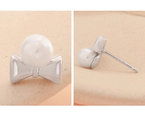 Vue détaillée des boucles d'oreilles nœud en argent S925 avec perles et poinçon métal