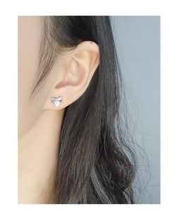 Gros plan de boucles d'oreilles nœud en argent S925 avec perles rondes sur un mannequin