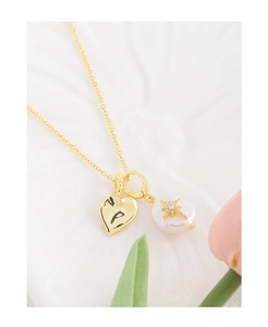 Détail du collier coeur perle baroque avec étoile et pendentif coeur doré brillant