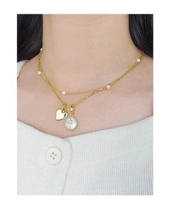 Détail du collier double couche en argent S925 doré avec perle, cœur et pendentif étoile