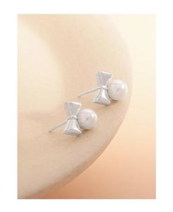 Macro des boucles d'oreilles nœud en argent avec texture S925 et éclat doux de la perle