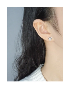 Détail des boucles d'oreilles nœud en argent avec perles blanches sur le mannequin