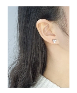 Gros plan d'élégantes boucles d'oreilles nœud en argent S925 avec perle sur l'oreille