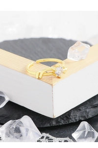 Detailed macro view of gold-plated twisted band ring with sparkling zircon stone inlay