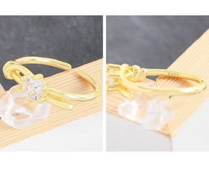 Detail showing S925 hallmark on the knotted silver ring with a sparkling zircon stone