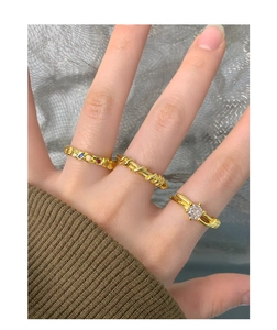 Close-up of three gold-plated silver rings featuring zircon and colorful gemstones