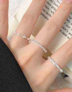 Detailed view of three S925 sterling silver rings with beaded and twisted designs on fingers