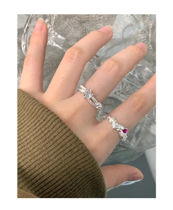 S925 silver rings with knot design and sparkling zircon on model finger close-up