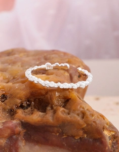 Close-up of S925 sterling silver beaded open ring on rustic stone with hallmarked engraving