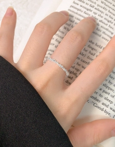 Macro detail of S925 sterling silver beaded ring on finger with aesthetic book background