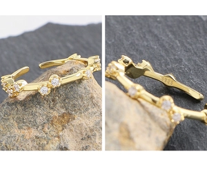 Macro detail of S925 hallmark on a minimalist gold geometric zircon open ring