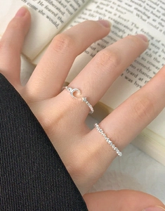 Detailed view of S925 sterling silver moon and star open rings worn on a hand over a book