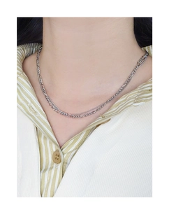 Close-up of a double-layered S925 silver chain necklace on a model wearing a striped shirt