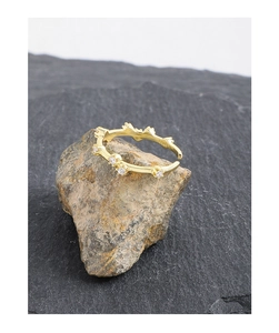 Macro detail of S925 sterling silver stamp on golden wavy zircon open ring