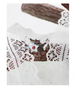 Macro detail of S925 silver irregular ring with gradient zircon star and lace background