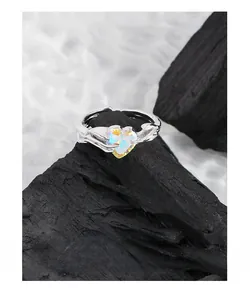 Macro detail of S925 silver ring featuring iridescent heart crystal and fluid texture