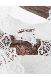 Macro detail of S925 sterling silver ring with an iridescent star stone on a wooden branch