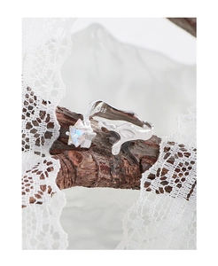 Macro detail of S925 sterling silver ring with colorful star zircon on bark texture