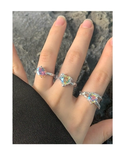 Macro detail of three silver rings with iridescent heart-shaped and oval zircon stones