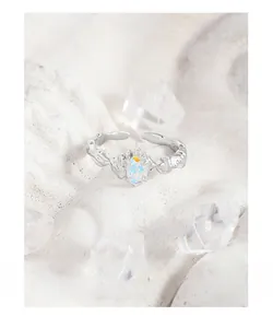 Macro shot of silver S925 irregular ring with iridescent opal on textured stone