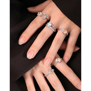 Hand wearing five S925 silver irregular rings with colorful zircon and stars on black background