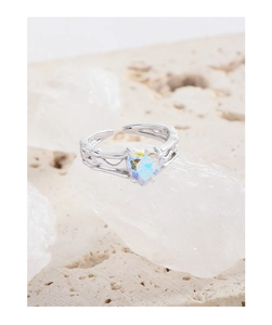Macro shot of silver ring with colorful heart zircon and hollow vine y2k design details